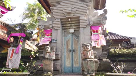 Balinesischer-Türeingang,-Traditionelles-Tor-In-Bali,-Indonesien,-Hinduistische-Statuen,-Ornamente-Und-Bunte-Stoffe-Und-Regenschirme