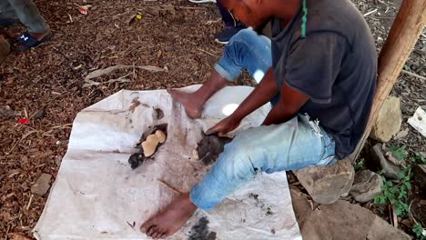Man-from-Makonde-tribe-skillfully-sands-intricate-ebony-sculpture-of-rhinoceros