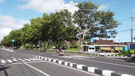 Big-Road-in-Bali,-Indonesia,-Bypass-Nugrah-Rai,-Street-Traffic,-Motorbikes,-Cars,-Scooters-Driving,-in-Ketewel,-Sukawati,-Gianyar-during-Sunny-Day-60-Fps