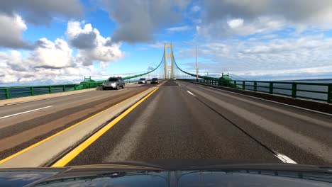 Driving-fast-over-Mackinaw-Bridge-in-Michigan-on-sunny-day,-POV