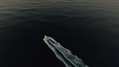 Ein-Boot,-Das-Diagonal-über-Den-Rahmen-In-Das-Morgendliche-Sonnenaufgangslicht-Segelt