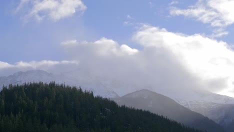 Flauschige-Wolkenlandschaft-über-Nebligen-Bergen-Mit-Nadelbäumen