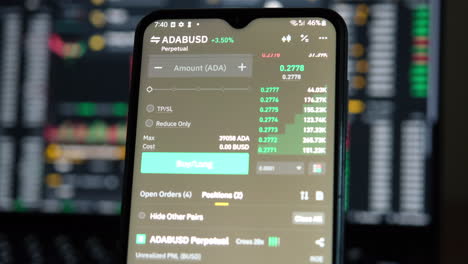Trading-cryptocurrency-on-the-phone-with-a-candle-stick-charts-in-the-background