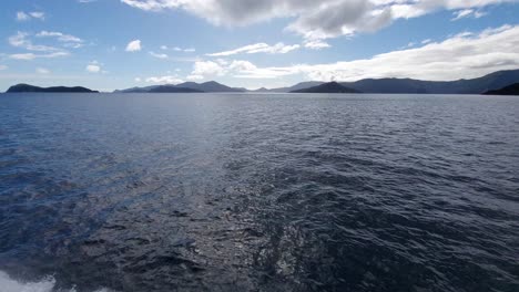 The-view-from-the-side-of-a-boat-as-it-sails-through-among-the-islands-in-the-sounds-at-the-top-of-the-South-Island-of-New-Zealand