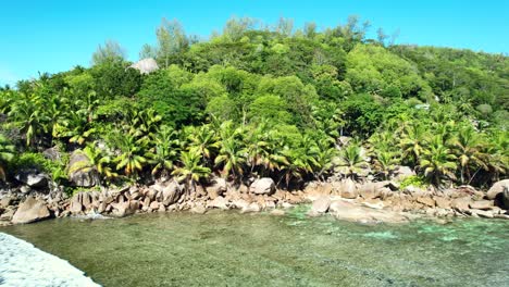 Mahe-Seychelles,-drone-shot-of-green-scenery,-rock-boulders,-crystal-clear-water-and-warm-climate
