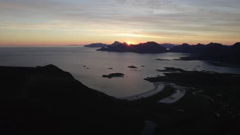 Peaceful-Sunrise-Kvalvika-Beach-drone-shot,-Middagstinden,-Lofoten,-Norway