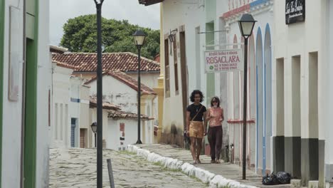 Two-people-walking-down-a-stone-street-old-city-center-of-Goias,-Brazil