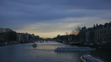 Amsterdam-Río-Amstel,-Puesta-De-Sol-En-Enero-De-2023,-Barco-Turístico-Pasando