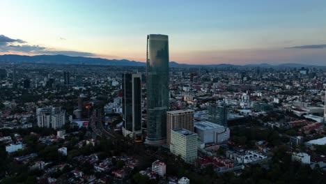 Aerial-view-around-the-Torre-Mitikah-complex,-evening-in-Benito-Juarez,-Mexico---orbit,-drone-shot