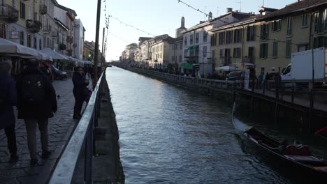 La-Gente-Camina-A-Lo-Largo-De-La-Orilla-Del-Canal-Naviglio-Milanés-Y-Se-Relaja-En-Los-Pubs,-Cámara-Lenta-30fps,-Milán,-Italia