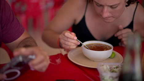 Slow-motion-close-up-of-a-latin-woman-stirring-his-barbacoa-broth-with-a-spoon-and-giving-it-a-sip-in-a-restaurant-in-Mexico