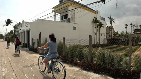 Women-riding-bikes-in-a-small-Vietnamese-town-among-rice-patties