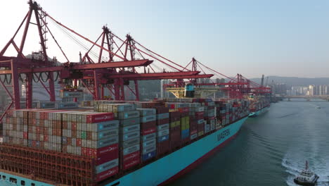 Grúa-Descargando-Un-Contenedor-De-Un-Gran-Buque-Portacontenedores-Maersk-Amarrado-En-El-Muelle-Del-Puerto-En-Hong-Kong