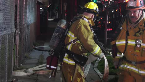 firefighter-rolls-up-hose-line