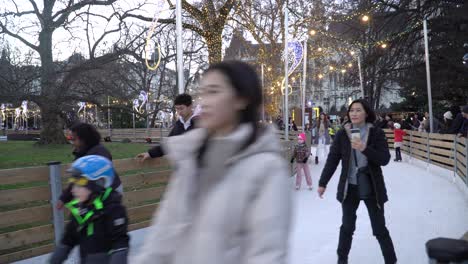 Tourists-having-fun-skating-on-the-outdoor-rink-on-Christmas-day-at-Town-Hall-in-Vienna,-Austria