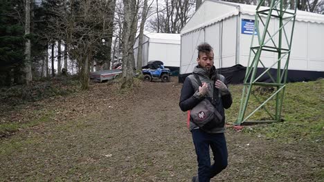 Man-hiking-outdoors-in-the-empty-ski-piste-without-snow-in-Januari-2023