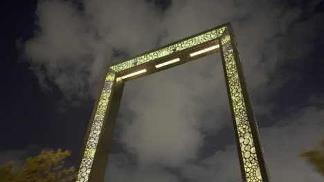 Slow-low-angle-moving-shot-of-The-Frame-of-Dubai-at-night