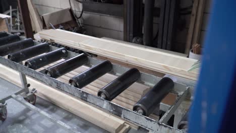Planks-of-wood-on-machinery-conveyor-belt