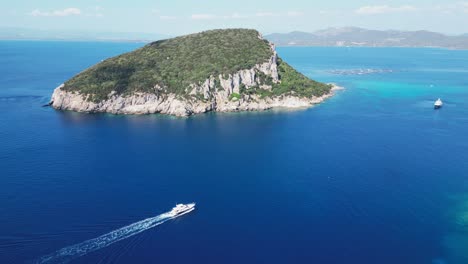 Boat-Sails-to-Figarolo-Island-in-Golfo-Aranci,-Sardinia,-Italy---Aerial-4k