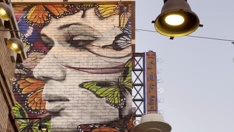 Graffiti-Eines-Frauengesichtes,-Umgeben-Von-Schmetterlingen-An-Einer-Ziegelwand