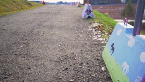 Bunte-Straßensperren-Aus-Beton-Mit-Street-Art-Gemälden-Auf-Einem-Kiesweg