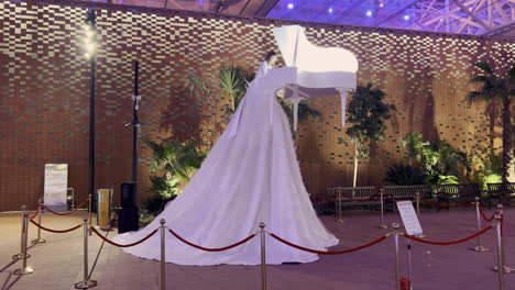 Chica-Con-Un-Enorme-Vestido-Blanco-Tocando-Un-Piano-Blanco-Flotante