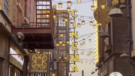 Light-sign-panel-Cinema-on-a-side-alley-between-brick-buildings-at-sunset