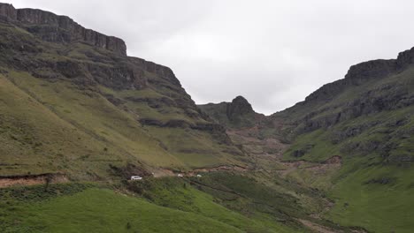 Four-sturdy-tourist-trucks-approach-dirt-switchbacks-on-Sani-Pass,-ZA