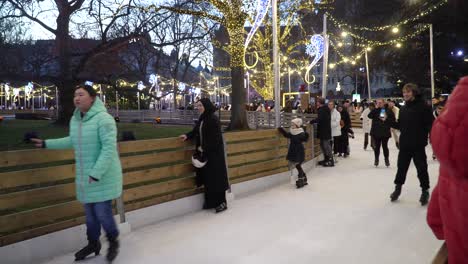People-enjoying-outdoor-ice-skating-on-Christmas-day-at-Town-Hall-in-Vienna,-Austria