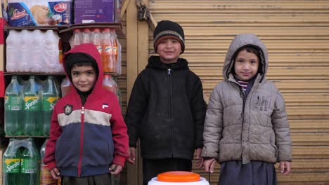 Grupo-De-Niños-Pequeños-Parados-En-La-Calle-Fuera-De-La-Tienda-En-Quetta,-Baluchistán