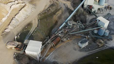 At-a-German-limestone-quarry-and-lime-processing-plant,-a-rock-truck-dumbs-into-the-feeder-of-a-conveyor-system