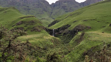 Water-falls-off-vibrant-green-grassy-Lesotho-plateau-in-Sani-Pass