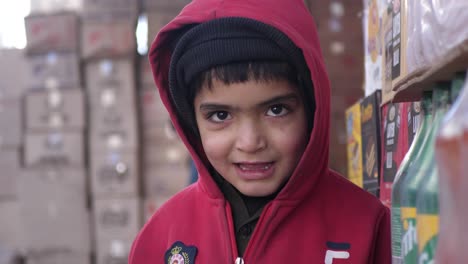 Joven-Con-Capucha-Roja-De-Pie-En-La-Calle-Mirando-A-La-Cámara-En-Quetta,-Baluchistán