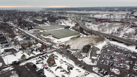 Aerial-view-of-bustling-snow-depots-with-dump-trucks-and-plows-collecting-snow-after-a-winter-storm