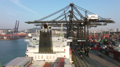 Aerial-rising-shot-over-container-ship-and-container-terminal-in-industrial-port-of-Hong-Kong-at-daytime