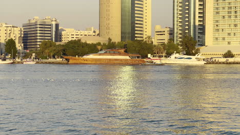 Luxuriöse-Holzyacht,-Die-Bei-Sonnenuntergang-Im-Hafen-Von-Dubai-Verankert-Ist