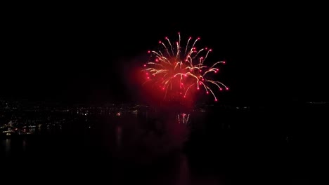 Amazing-public-fireworks-from-city-of-Bergen-during-new-year-celebration-entering-year-of-2023---Aerial-close-to-fireworks-over-byfjorden-fjord