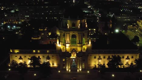 Pasadena-City-Hall-at-night-with-Christmas-tree,-aerial-pull-back-over-city-lights,-establishing-cinematic-view