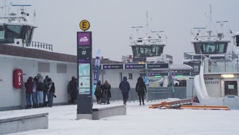 Passagiere,-Die-Sich-Auf-Den-Weg-Machen,-Ein-Boot-Am-Pier-Von-Aker-Brygge-Mit-Starkem-Schneefall-Zu-Besteigen