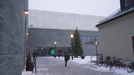 Visitors-Walking-Along-Path-Towards-Entrance-Of-The-National-Museum-of-Art,-Architecture,-and-Design-In-Oslo,-Norway-With-Snow-Falling