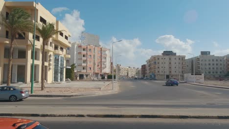 Hurghada,-Egypt-29-December-2022,-Daytime-City-View-Through-the-Bus-Window,-Traffic,-Houses,-Architecture,-People