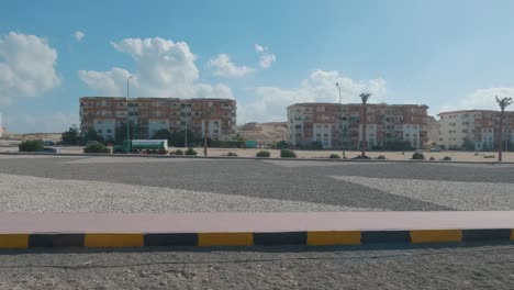 Hurghada,-Egipto-29-De-Diciembre-De-2022,-Vista-De-La-Ciudad-Durante-El-Día-A-Través-De-La-Ventana-Del-Autobús,-Tráfico,-Casas,-Arquitectura,-Personas