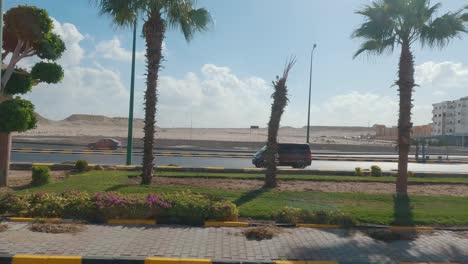 Hurghada,-Egypt-29-December-2022,-Daytime-City-View-Through-the-Bus-Window,-Traffic,-Houses,-Architecture,-People