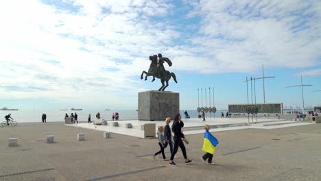 Child-Wears-Ukraine-Flag-near-Alexander-the-Great-Statue-in-Thessaloniki