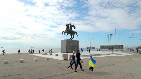 Niño-Viste-La-Bandera-De-Ucrania-Cerca-De-La-Gran-Estatua-De-Alejandro-En-Tesalónica