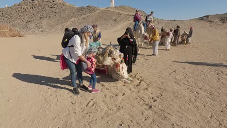 Hurgada,-Egypt-29-December-2022:-the-Camels-in-Sahara-Desert,-Egypt,-traditional-Dressed-Bedouins-Riding-Tourists-on-Camels-Through-Sandy-Desert