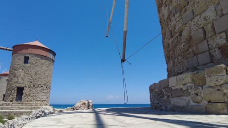 Low-Angle-Shot-Neben-Windmühlen-Bei-Mandraki-Mit-Blauem-Himmel-In-Rhodos