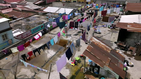 Slow-motion-aerial-footage-of-clothes-drying-on-the-roof-of-a-building-in-San-Juan-Ostuncalco,-Guatemala