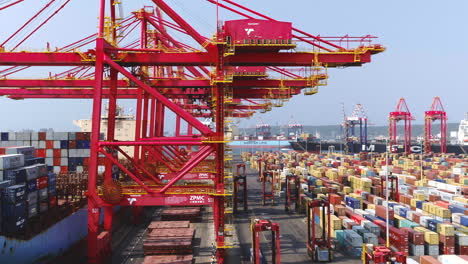 Aerial-drone-shot-of-gantry-cranes-and-saddle-cranes-loading-a-large-cargo-ship-in-Durban-Harbour