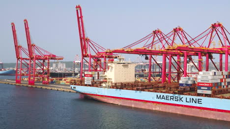 Aerial-drone-shot-of-a-large-container-cargo-ship-being-loaded-with-shipping-containers